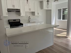 Gardena apartment for rent - A kitchen with white cabinets and a black stove top oven.